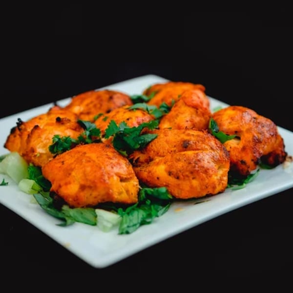 Zaffron's Afghan chicken tikka, garnished with fresh cilantro and served on a bed of lettuce.